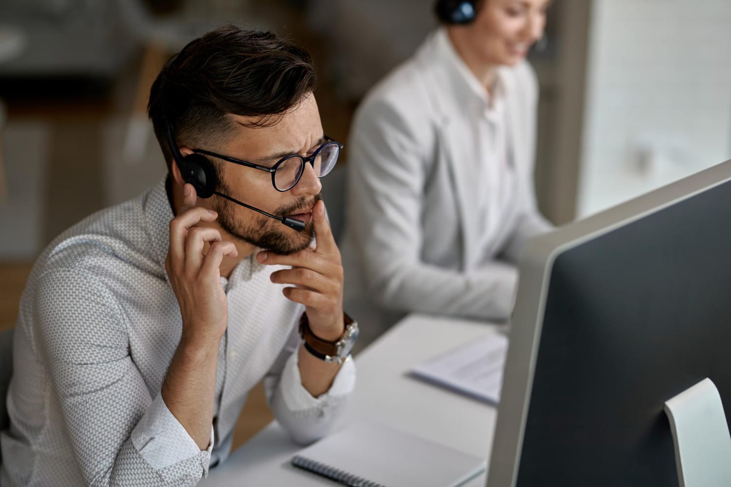 Concentrated Call Center Agent Talking With Customer While Working Office